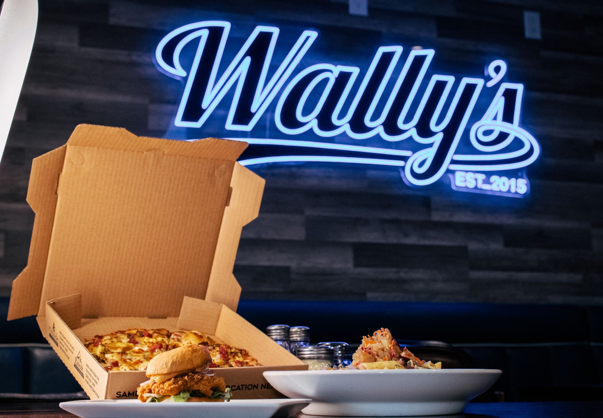Wally's neon sign with food spread
